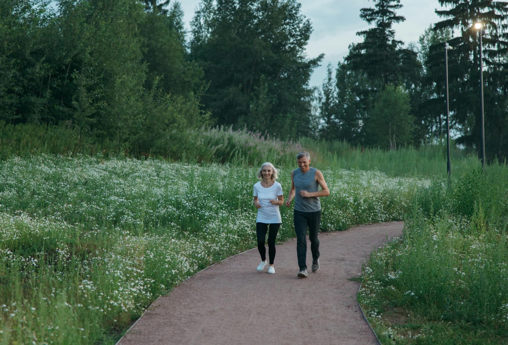 Couple walking together on a paved forest trail