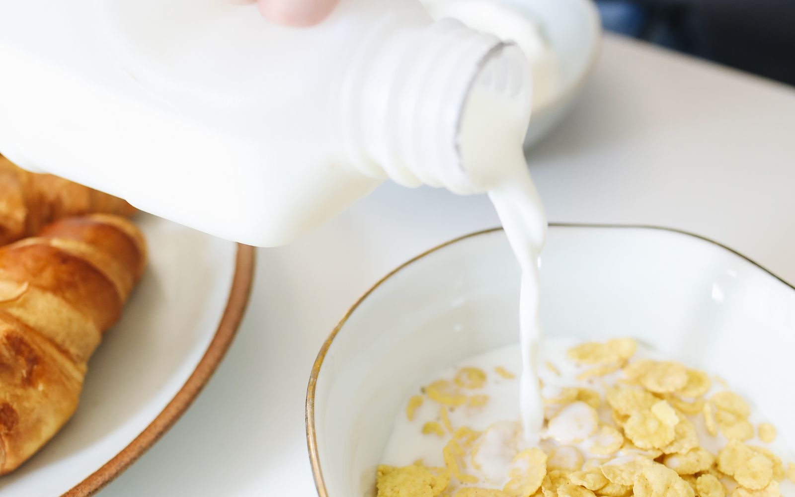 Milk being poured into a bowl of breakfast cereal